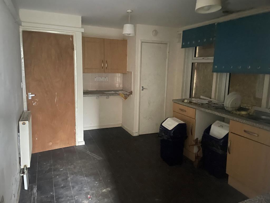 Lot: 144 - PROPERTY ARRANGED AS TWO FLATS - Kitchen for 11 Trevose Road with units, radiators and boarded up windows
